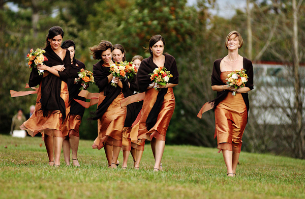 bridesmaids in orange knee length dresses covered by dark brown shawls -photo by North Carolina wedding photographer Richard Israel 